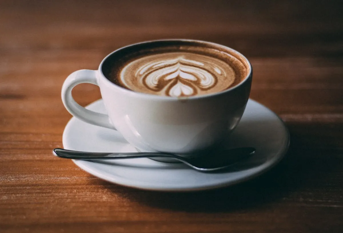 Kaffeehaus-Tisch mit Tasse und kleinen Köstlichkeiten